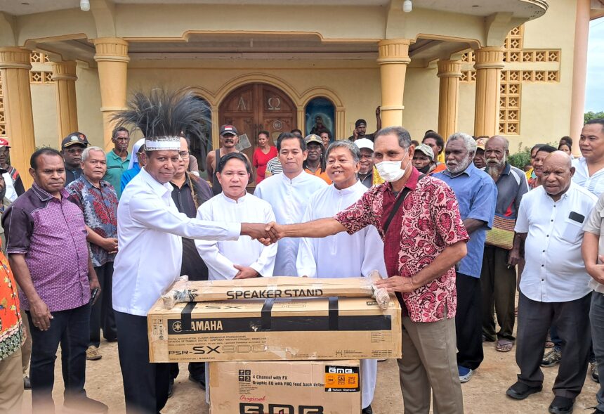 Pj. Gubernur Papua Selatan, Apolo Safanpo saat memberikan bantuan Alat Musik kepada Gereja Paroki St. Fransiskus Xaverius Asiki. (Foto: tiffanews.co.id/Ron)